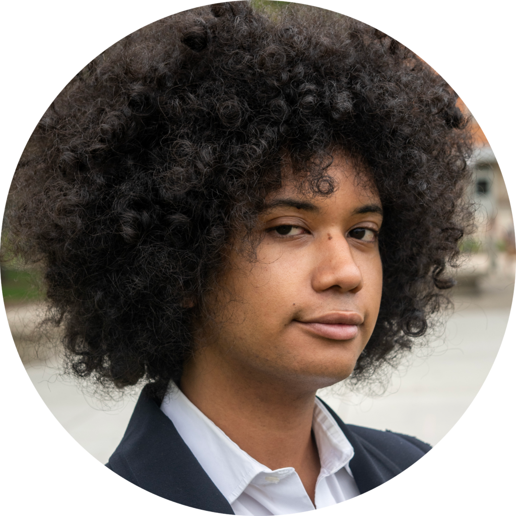 A man wearing a suit, with dark curly hair